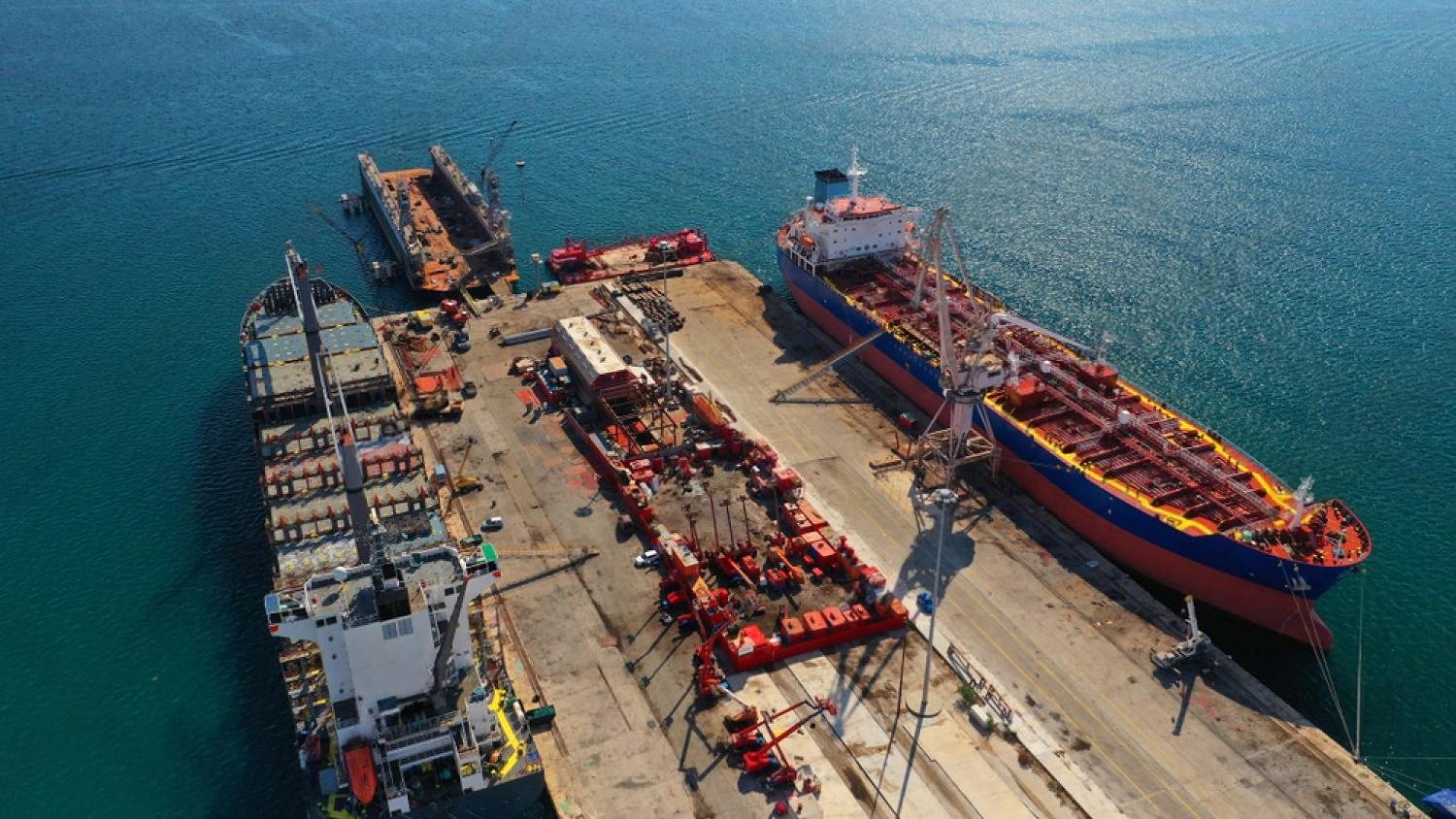 Aerial view of cargo vessels and tankers docked at a Middle East port terminal